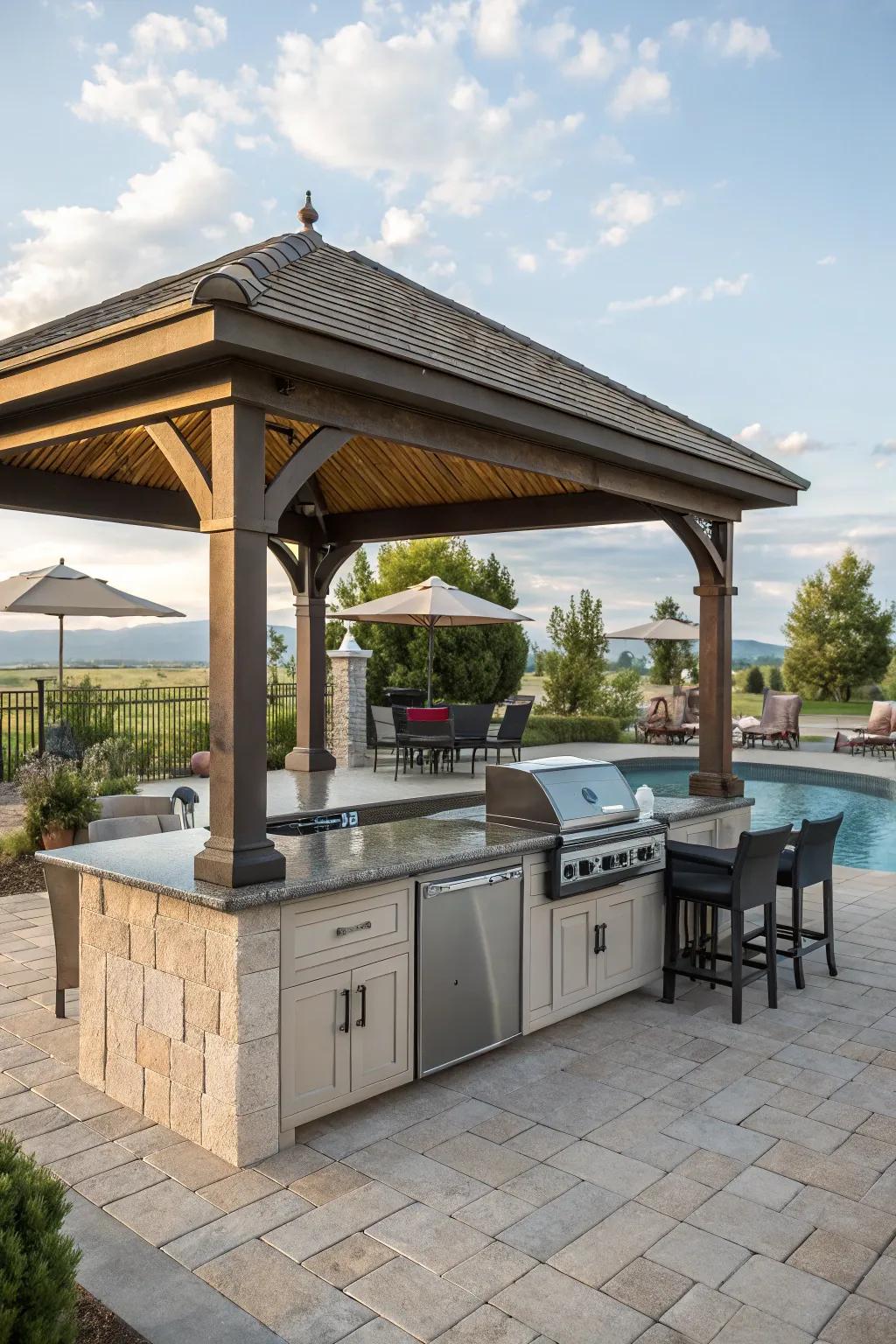 A cozy gazebo-covered kitchen with a stunning pool view.