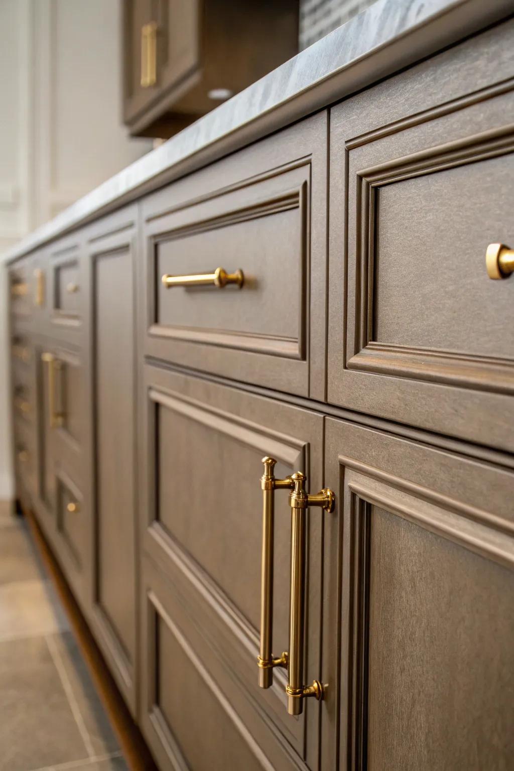 Metallic handles add glamour to dark beige cabinets.