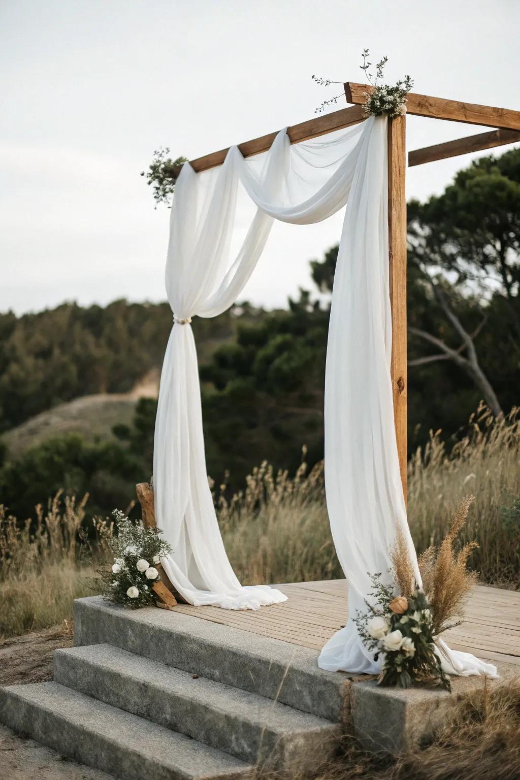 Create a breathtaking ceremony with a simple yet stunning fabric-draped arch, embodying minimalist elegance.